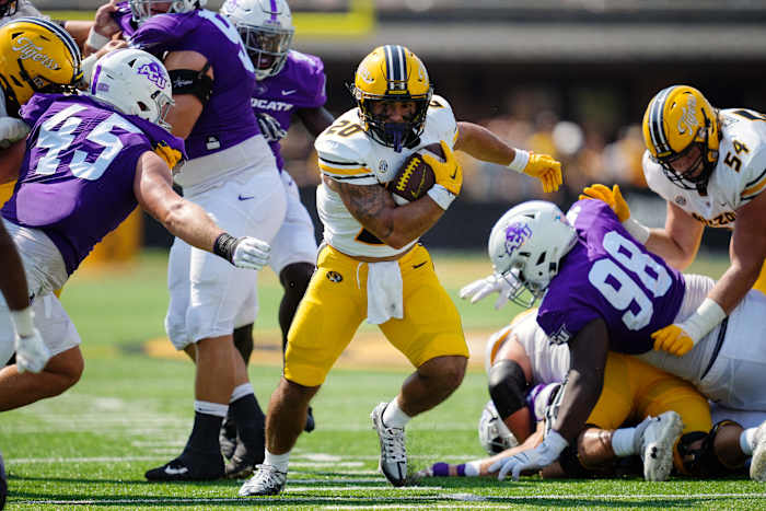 Sep 17, 2022; Columbia, Missouri, USA; Missouri Tigers running back Cody Schrader (20) runs the ball against Abilene Christian Wildcats defensive lineman Jordan Paup (45) and defensive lineman David Oke (98) during the first half at Faurot Field at Memorial Stadium. Mandatory Credit: Jay Biggerstaff-USA TODAY Sports